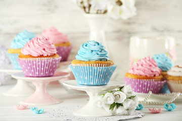 Delicious cupcakes on table on light background