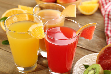 Fresh juices with fruits on wooden table