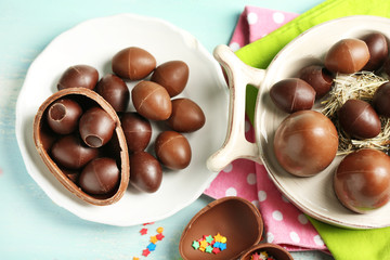 Chocolate Easter eggs on plate, on color wooden background