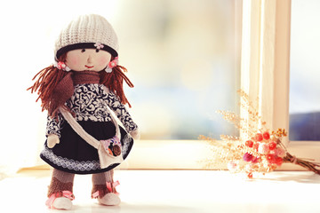Handmade doll near window close-up