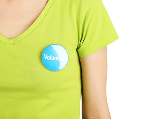 Round volunteer button on shirt of girl isolated on white