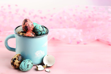 Bird colorful eggs in mug on bright background