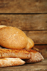 Different fresh bread on old wooden table