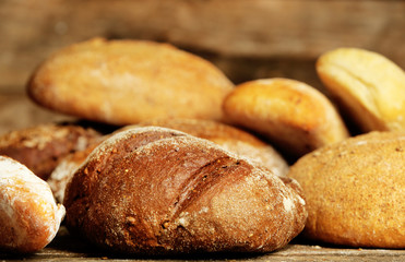 Different fresh bread on old wooden table
