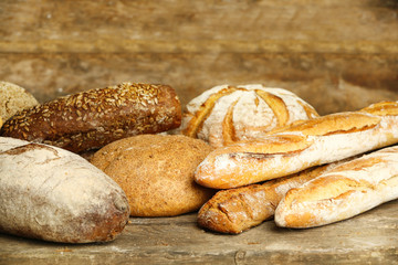 Different fresh bread on old wooden table