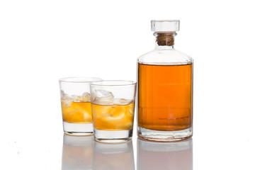 Two whiskey on the rocks, with a whiskey bottle