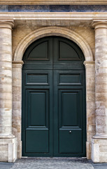 Fototapeta na wymiar Old wooden front door painted black in Paris