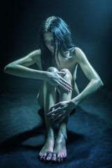 The naked woman on a black background