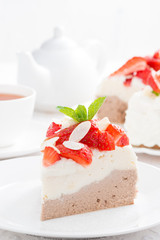 piece of cake with whipped cream, strawberries and tea, vertical