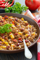 spicy Mexican dish chili con carne in a brown pottery plate