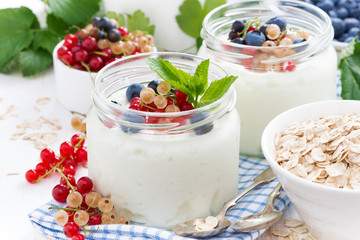 yogurt with fresh berries and breakfast foods on table