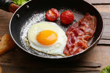Bacon and eggs on rustic wooden planks background