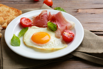 Bacon and eggs on rustic wooden planks background