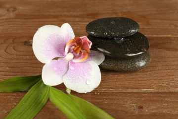 Obraz na płótnie Canvas Spa stones with orchid on wooden background