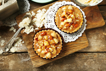 Obraz na płótnie Canvas Mini cakes with nuts on wooden background