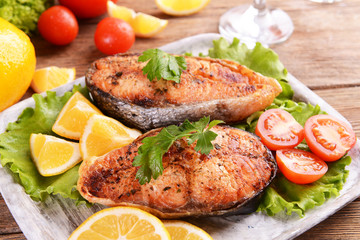 Tasty baked fish on plate on table close-up