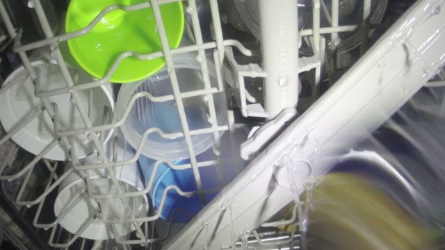 Interior view dishwasher cleaning a full load of dishware