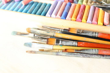 Paintbrushes with colorful chalk pastels in box