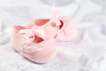 Obraz na płótnie Canvas Pink baby boots on cloth close-up