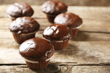 Tasty homemade chocolate muffins on wooden table