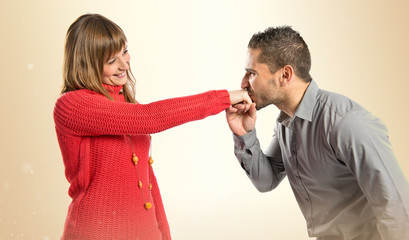 man kissing a woman's hand over white background.