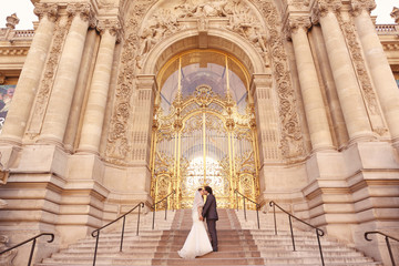 Bride and groom in front of a big building