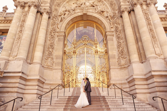 Bride and groom in front of a big building
