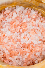 pink himalayan salt in a mortar on wooden surface