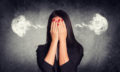 Close-up portrait of businesswoman hiding face in her hands