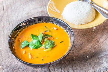Delicious Thai panang curry and rice on wood background.