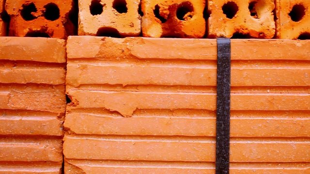 Close up of packing the red brick. Macro video shift motion