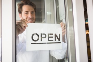 Smiling chef putting up a sign on window