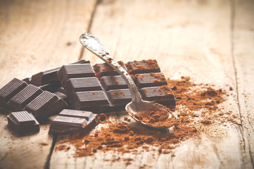 Noble dark chocolate on a wooden table in vintage style.