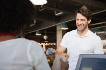 Customer paying by credit card her bread