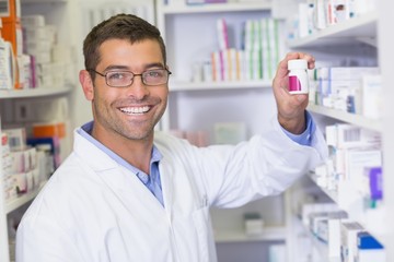 Handsome pharmacist holding medicine jar