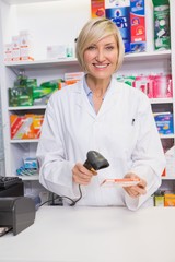Smiling pharmacist scanning box of medicine