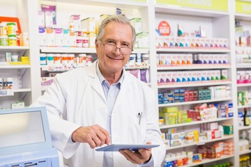 Smiling pharmacist using tablet pc