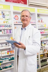 Smiling pharmacist using tablet pc