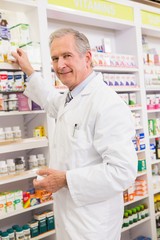 Pharmacist taking medicine from shelf