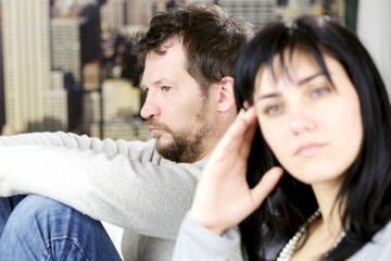 Depressed man not looking at wife after fight