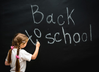 little girl wrote in chalk on black chalkboard