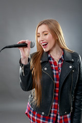 a beautiful blonde woman singing in microphone