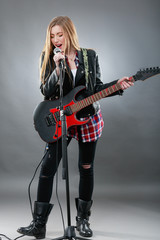 Beautiful young,blond woman with a electric guitar