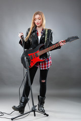 Beautiful young,blond woman with a electric guitar