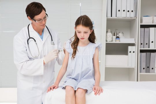 Doctor doing injection at a little girl