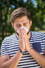 Handsome hipster blowing his nose