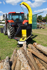 Wood cutter machinery next to a new tractor