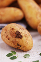 Rohe festkochende Kartoffeln auf Holzbrett