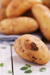 Rohe festkochende Kartoffeln auf Holzbrett