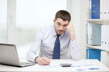 Obraz premium stressed businessman with laptop and documents